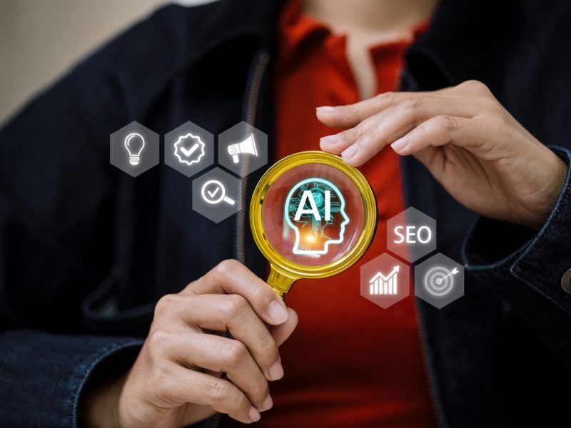 Close up of professional auditing an artificial intelligence system through a magnifying glass. Concept of AI verification, search engine optimization, and data-driven business growth.